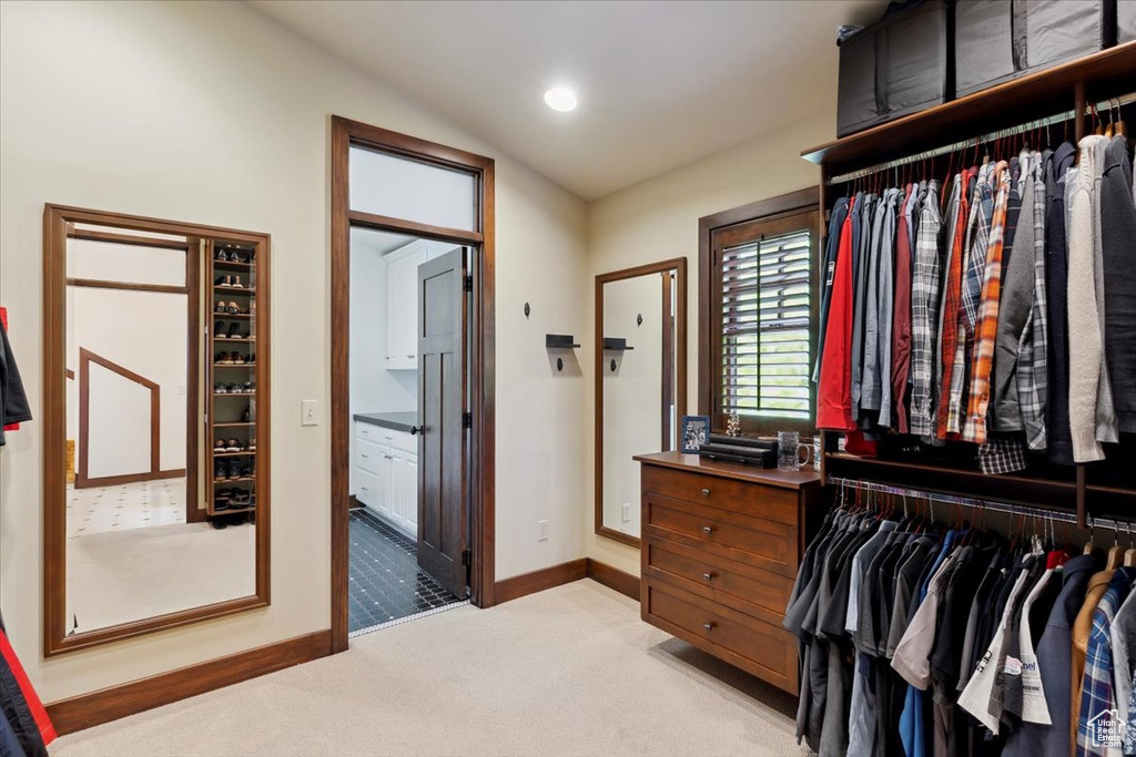 Walk in closet with light colored carpet and lofted ceiling