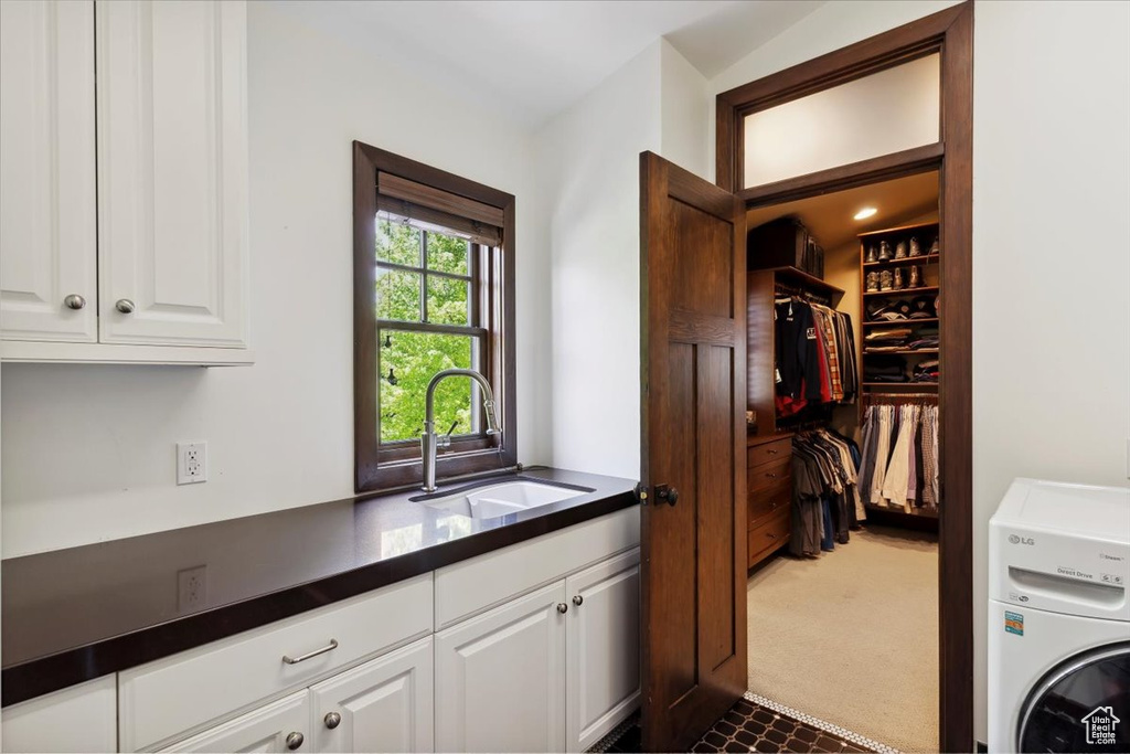 Washroom featuring cabinet space, washer / dryer, and dark carpet