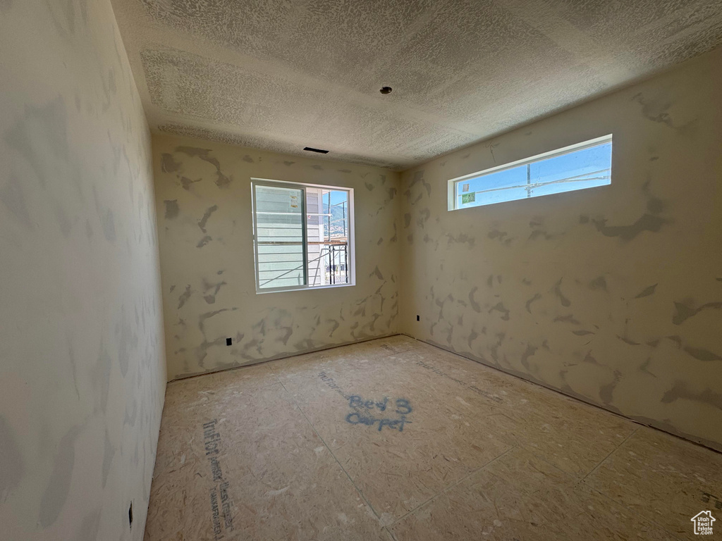 Spare room with healthy amount of natural light and a textured ceiling