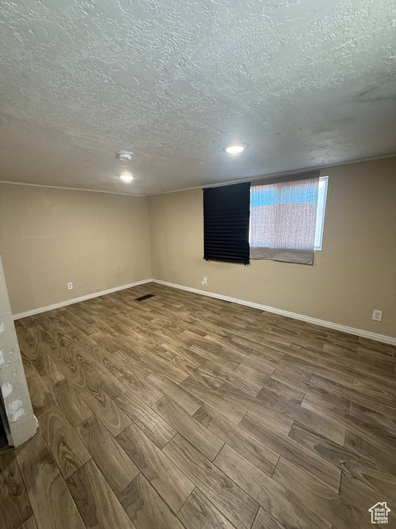 Spare room featuring a textured ceiling, wood finished floors, and recessed lighting
