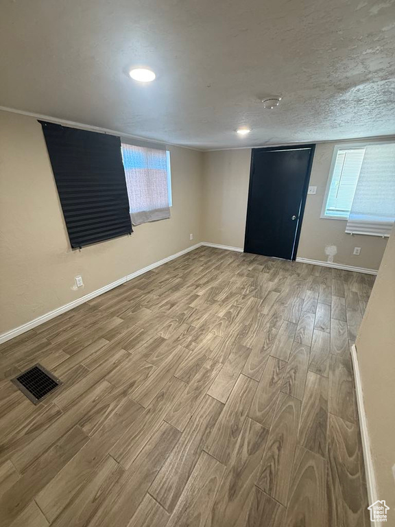 Empty room featuring wood finished floors, plenty of natural light, and recessed lighting