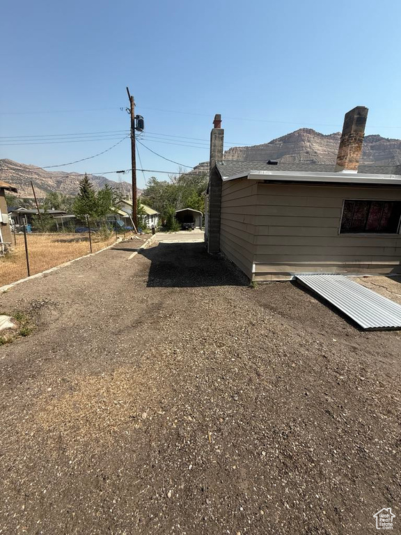 View of home\'s exterior with a chimney and dirt driveway