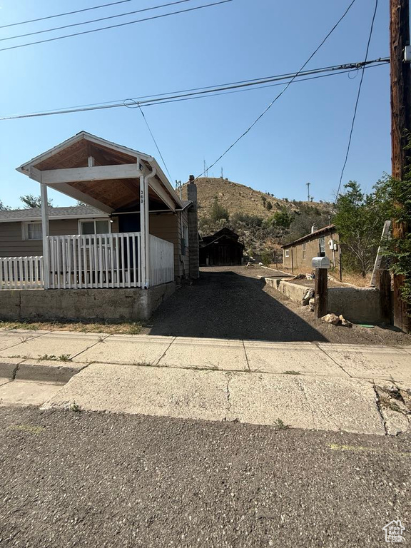 View of property exterior with driveway and a porch