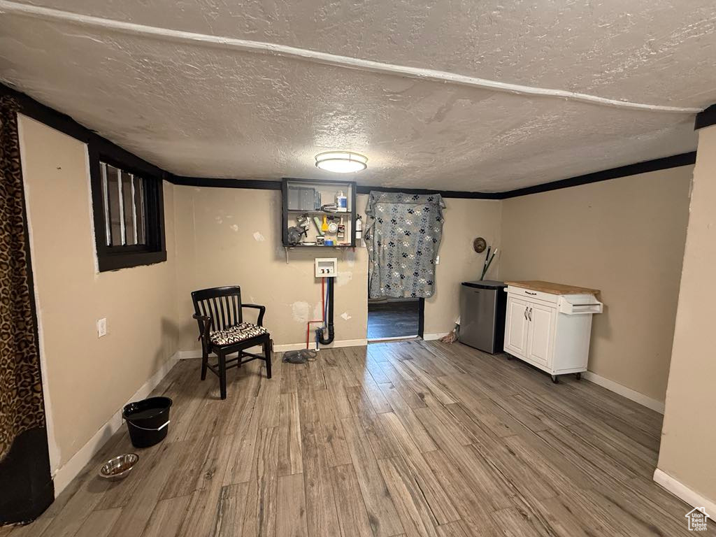 Unfurnished room featuring wood finished floors and a textured ceiling