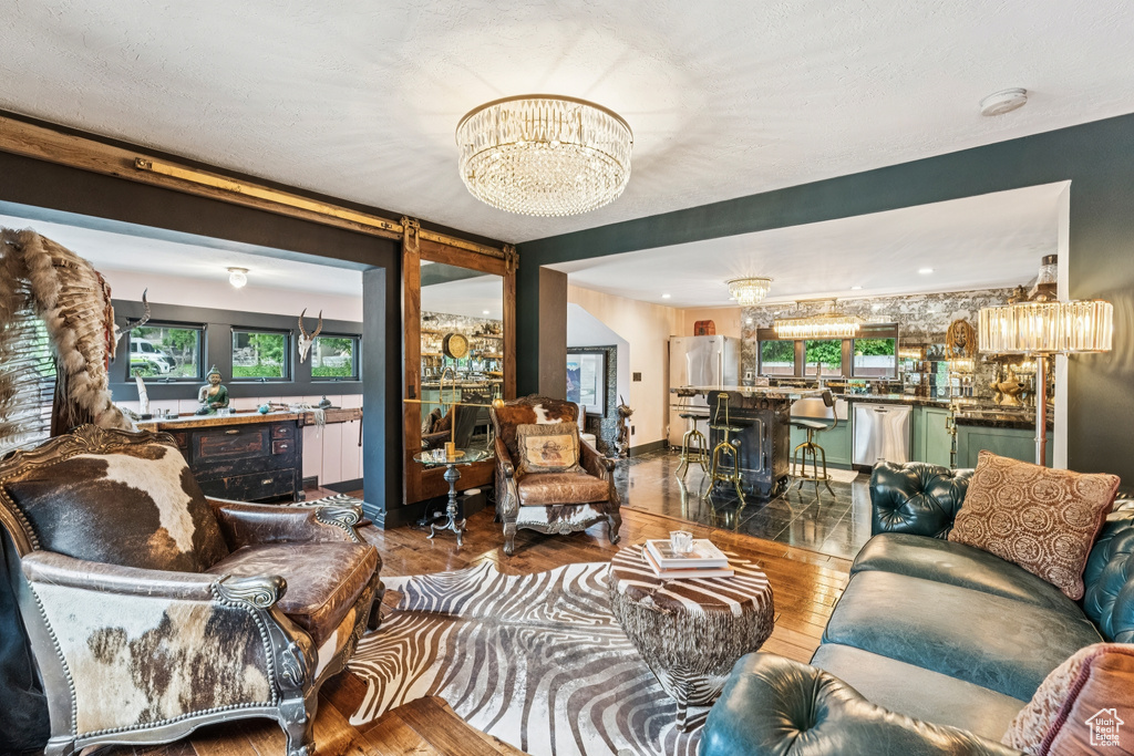 Living room featuring a chandelier, wood finished floors, and plenty of natural light