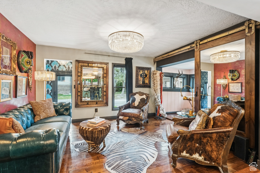 Living room with a chandelier, wood-type flooring, and a textured ceiling