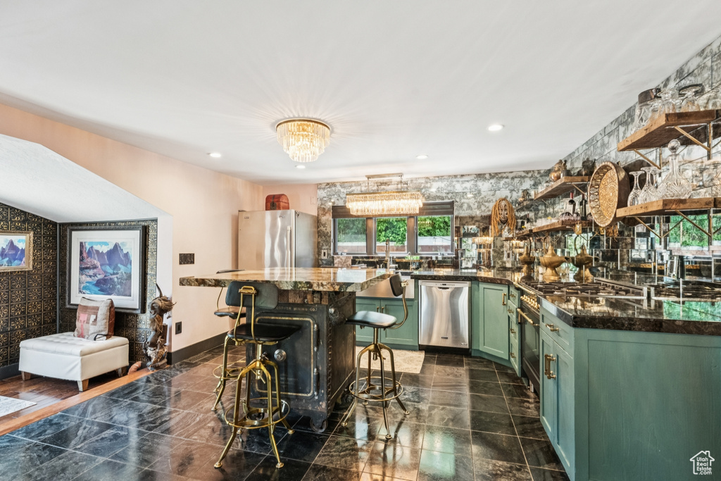 Kitchen with green cabinetry, stainless steel appliances, open shelves, recessed lighting, and a chandelier