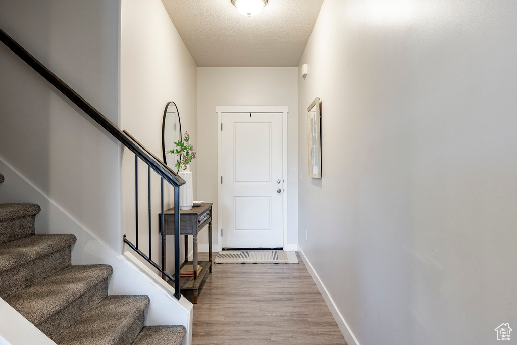 Doorway with wood finished floors and stairs
