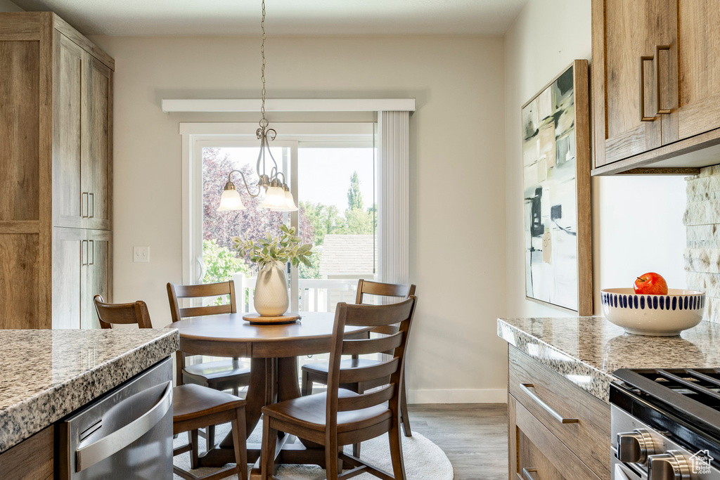 Dining space with wood finished floors and a chandelier