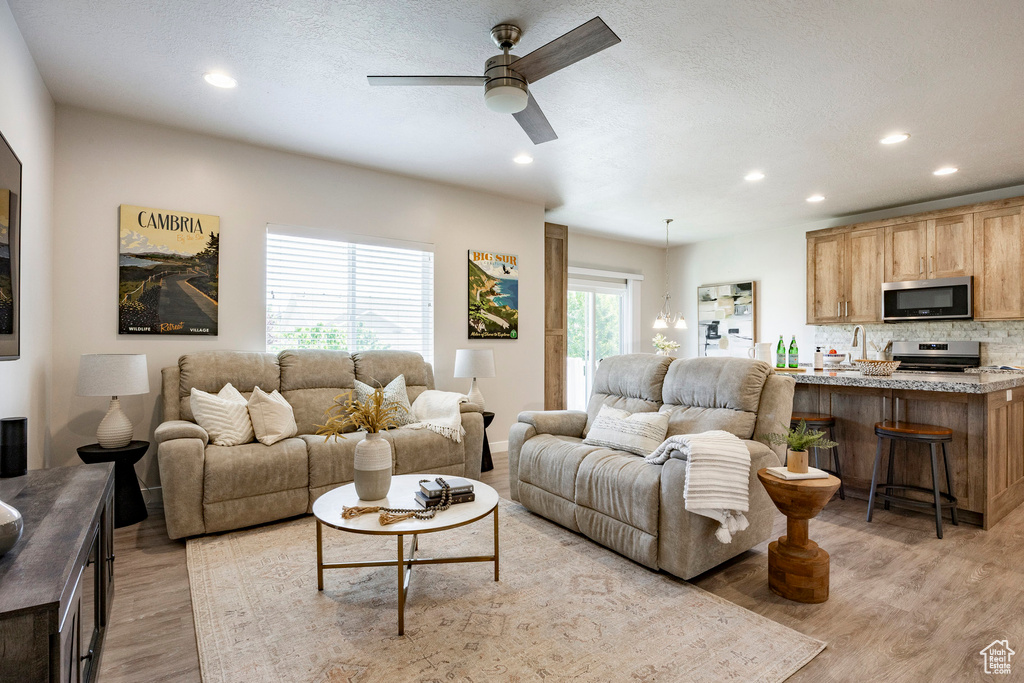 Living room featuring recessed lighting, light wood-style floors, and ceiling fan