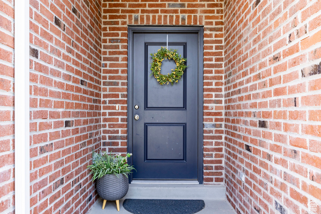 Doorway to property featuring brick siding
