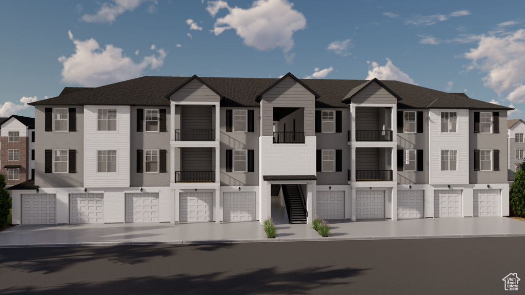 View of front of home with an attached garage and stucco siding