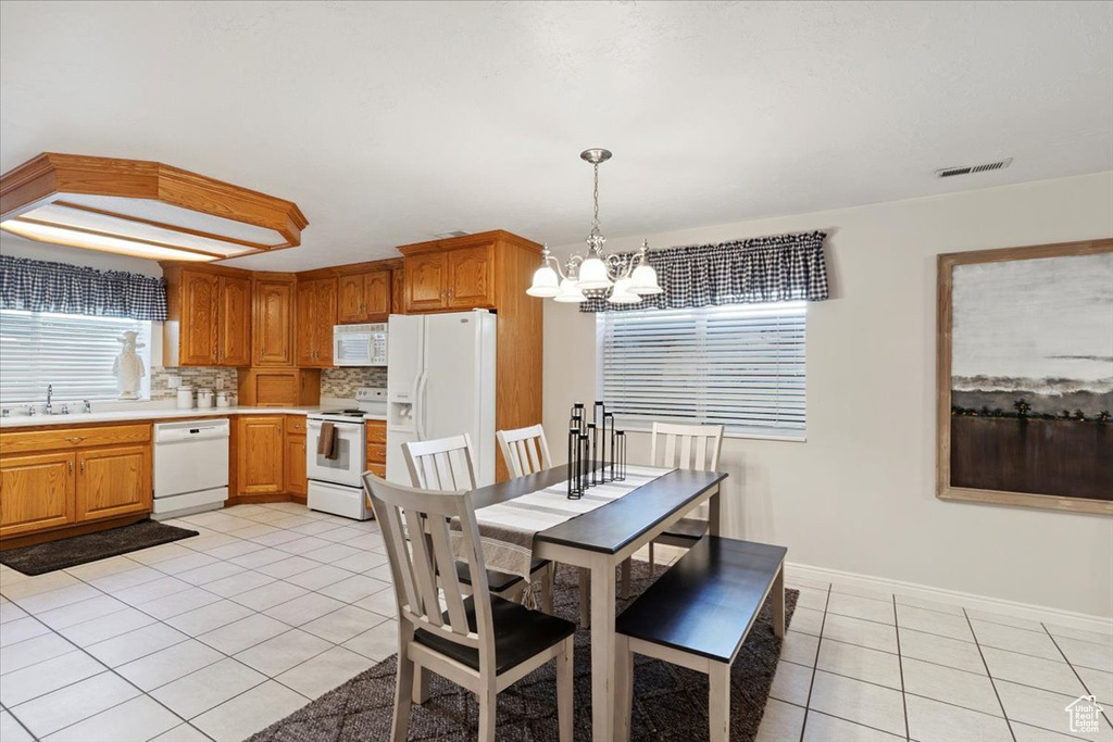 Dining area featuring light tile patterned flooring and a chandelier