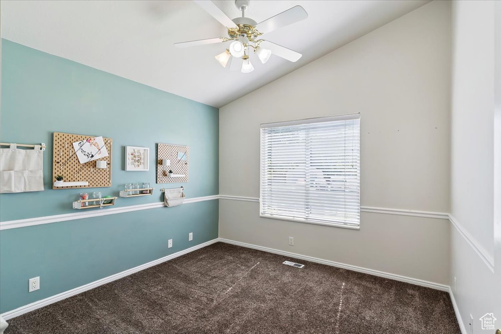 Empty room featuring carpet floors, lofted ceiling, and ceiling fan