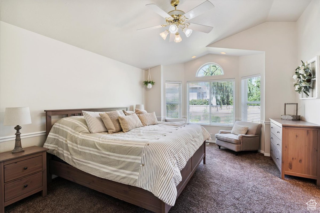 Carpeted bedroom with lofted ceiling and ceiling fan