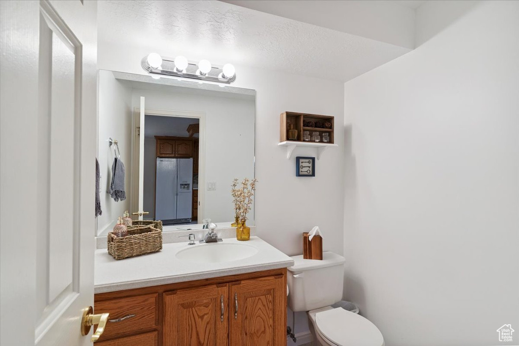 Half bath featuring toilet and vanity