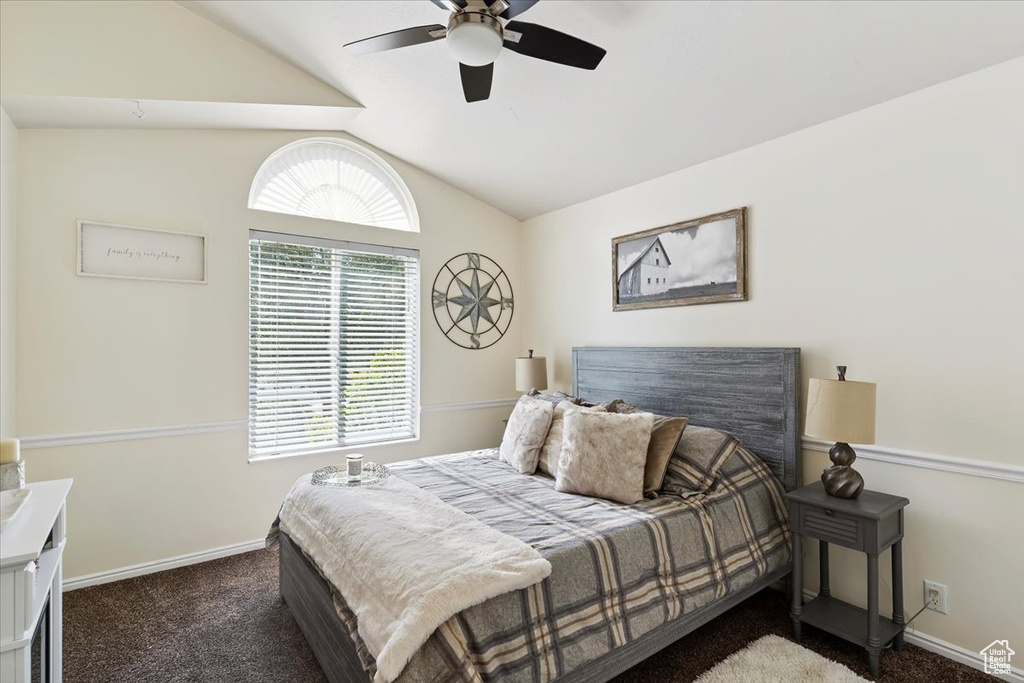 Bedroom featuring carpet, vaulted ceiling, and a ceiling fan