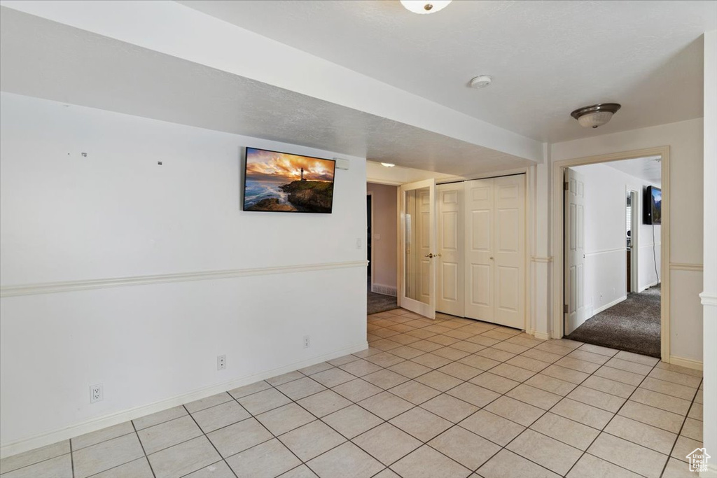 Unfurnished room featuring a smoke detector and light tile patterned floors