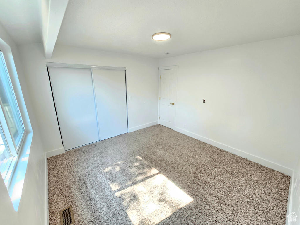 Unfurnished bedroom with carpet floors and a closet