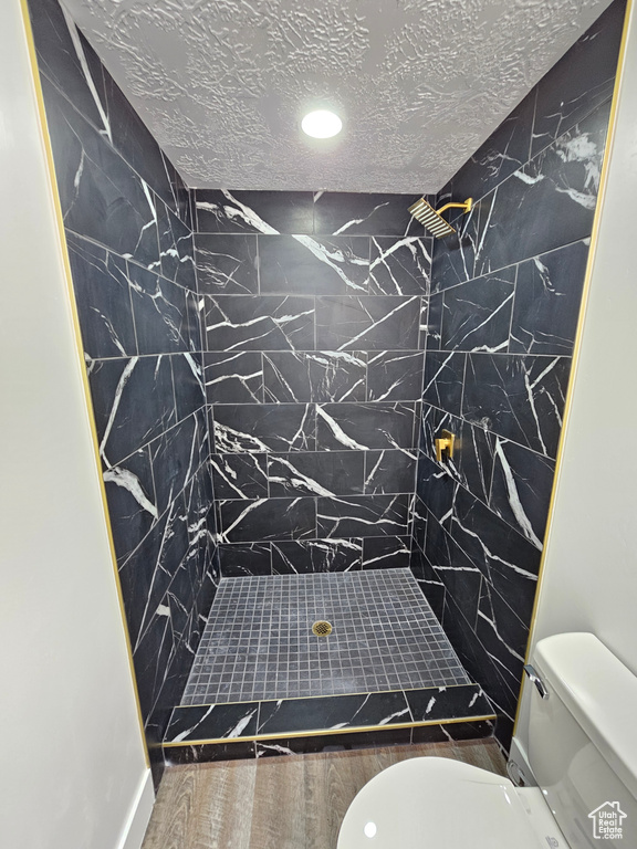 Bathroom with a shower stall, recessed lighting, and wood finished floors