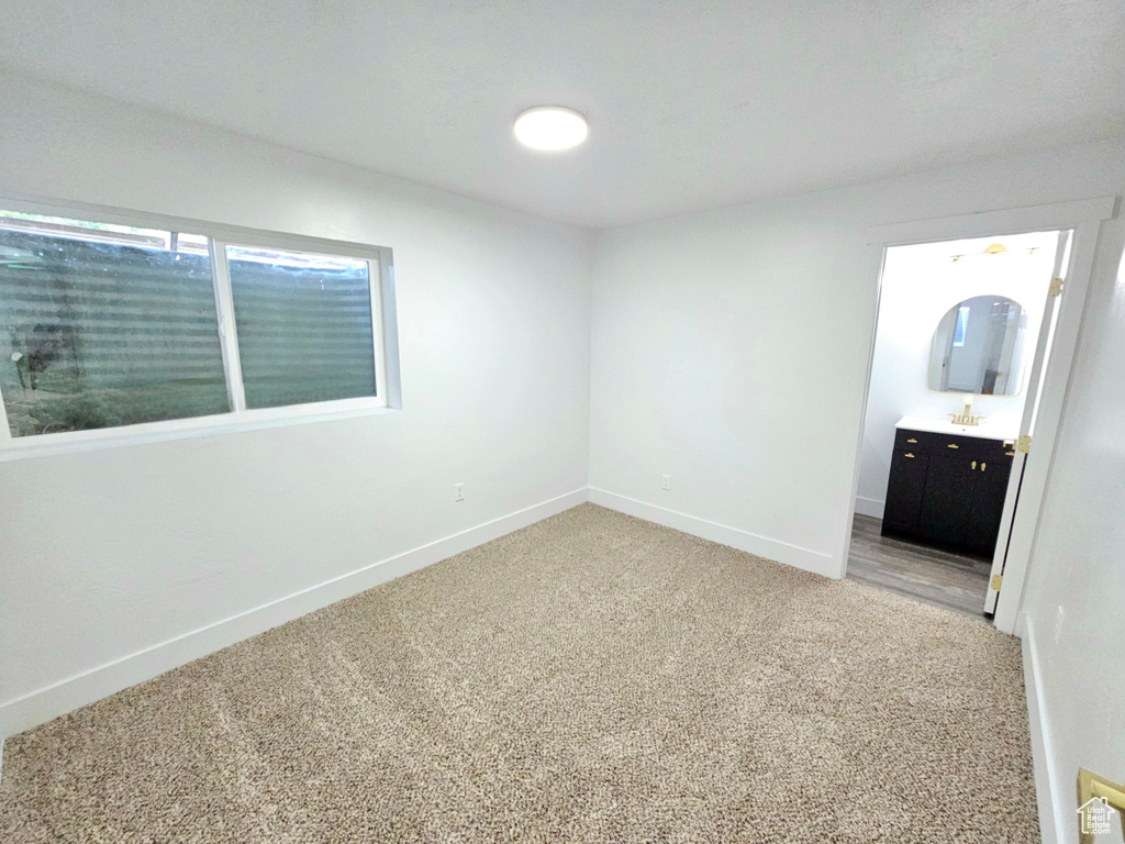 Unfurnished bedroom featuring light colored carpet and baseboards