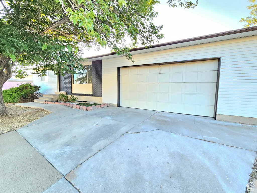 View of front of home with driveway and a garage