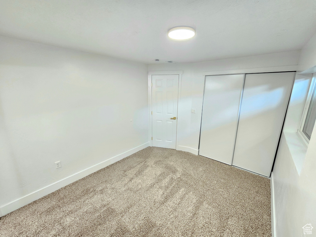 Unfurnished bedroom featuring carpet floors and a closet