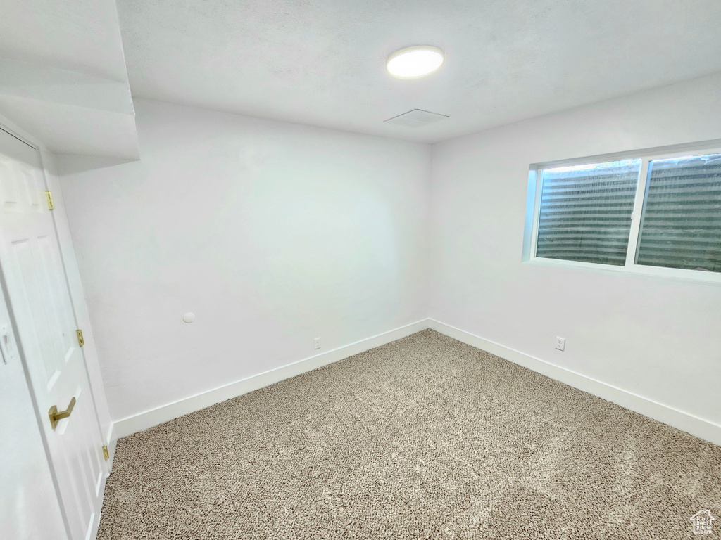 Empty room featuring light carpet