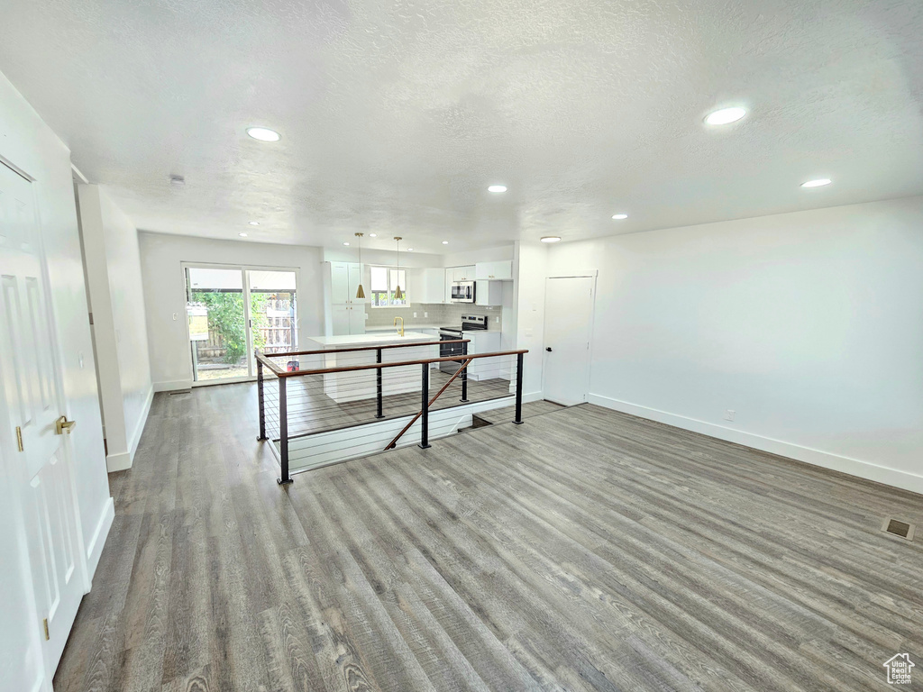 Recreation room featuring recessed lighting, wood finished floors, and a textured ceiling
