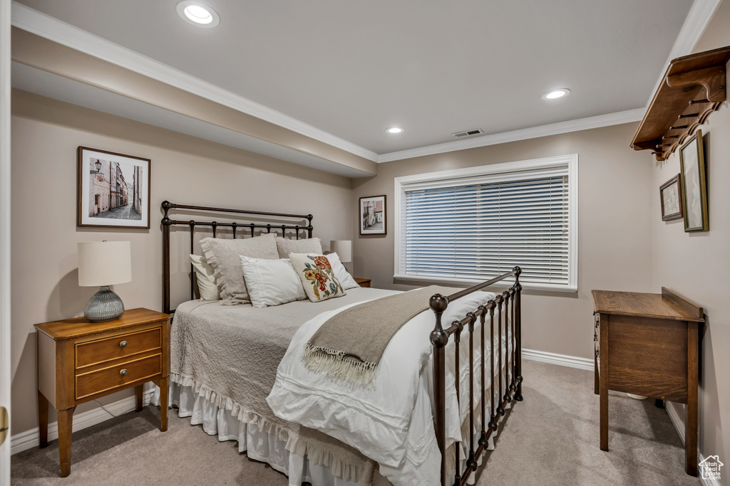 Bedroom with light colored carpet, crown molding, and recessed lighting