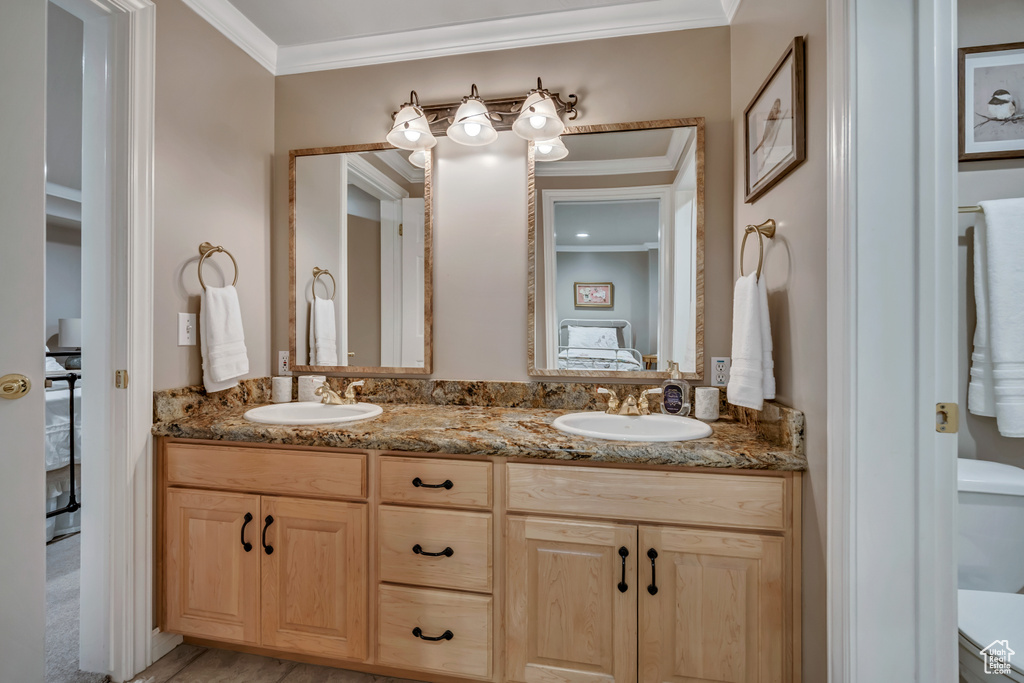 Full bathroom featuring connected bathroom, double vanity, and crown molding