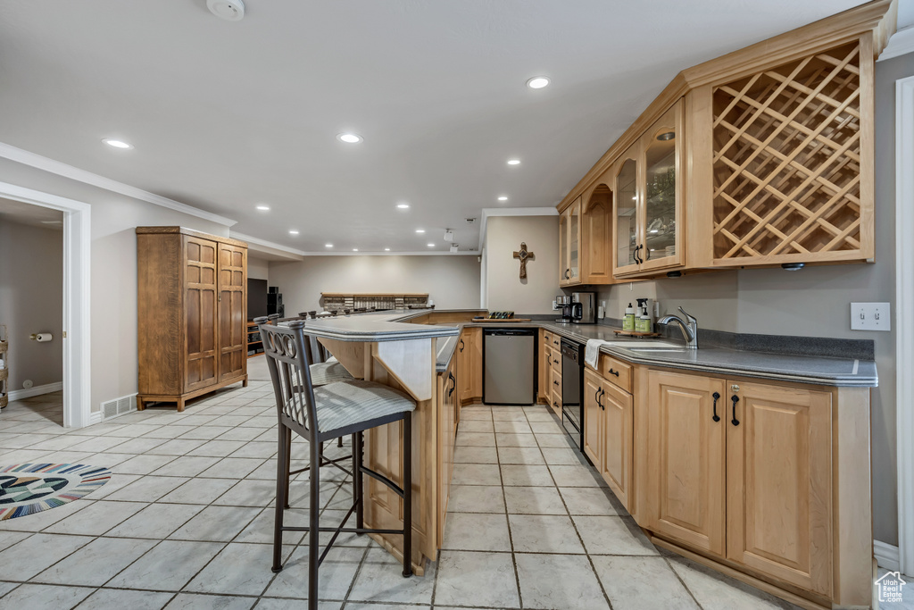 Kitchen featuring dishwasher, recessed lighting, ornamental molding, dark countertops, and a kitchen bar