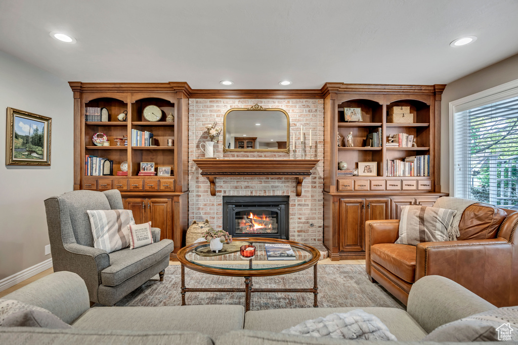 Living room featuring recessed lighting, a brick fireplace, and light wood-style floors