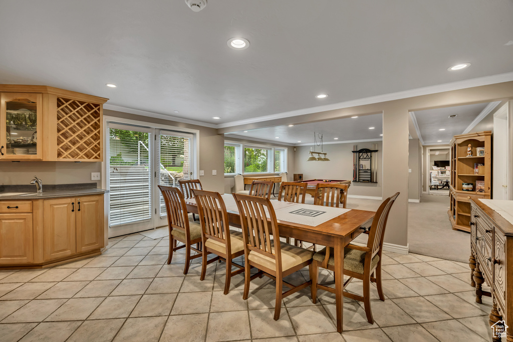 Dining area featuring ornamental molding, bar with sink, recessed lighting, and light tile patterned flooring
