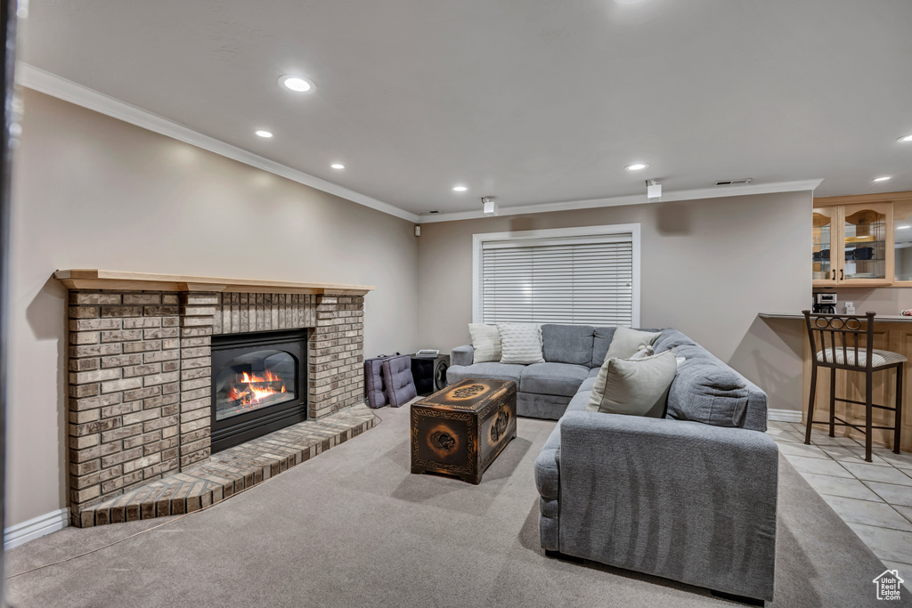 Living area featuring crown molding, recessed lighting, a fireplace, and light carpet