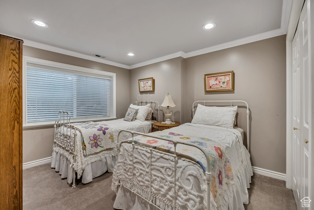 Bedroom with a closet, carpet flooring, recessed lighting, and crown molding