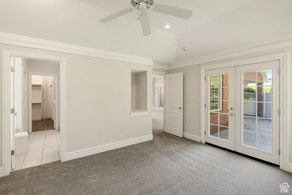 Carpeted empty room featuring french doors, a ceiling fan, lofted ceiling, recessed lighting, and tile patterned flooring