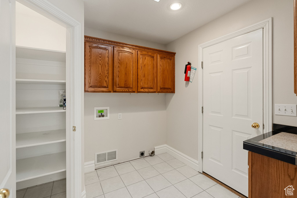 Laundry room featuring washer hookup, light tile patterned floors, cabinet space, electric dryer hookup, and recessed lighting