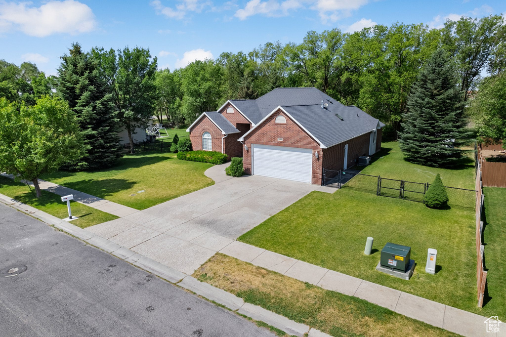 View of front of property featuring brick siding, driveway, and an attached garage