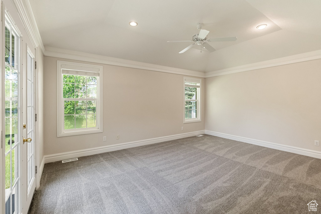 Carpeted spare room with plenty of natural light, a ceiling fan, recessed lighting, crown molding, and lofted ceiling