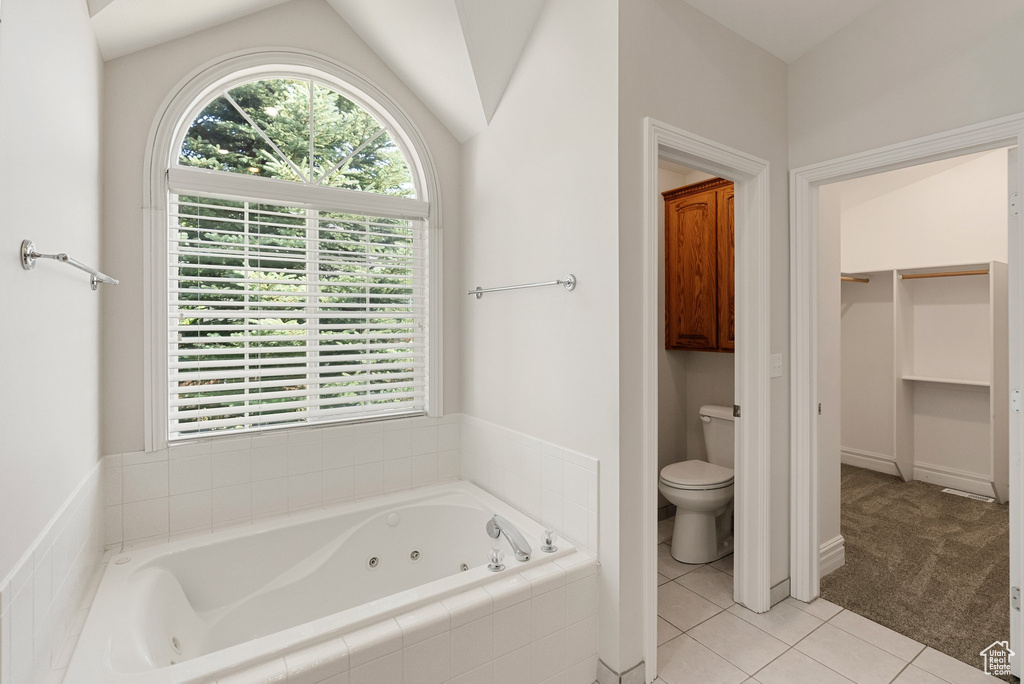 Full bathroom featuring a jetted tub, tile patterned floors, and a spacious closet