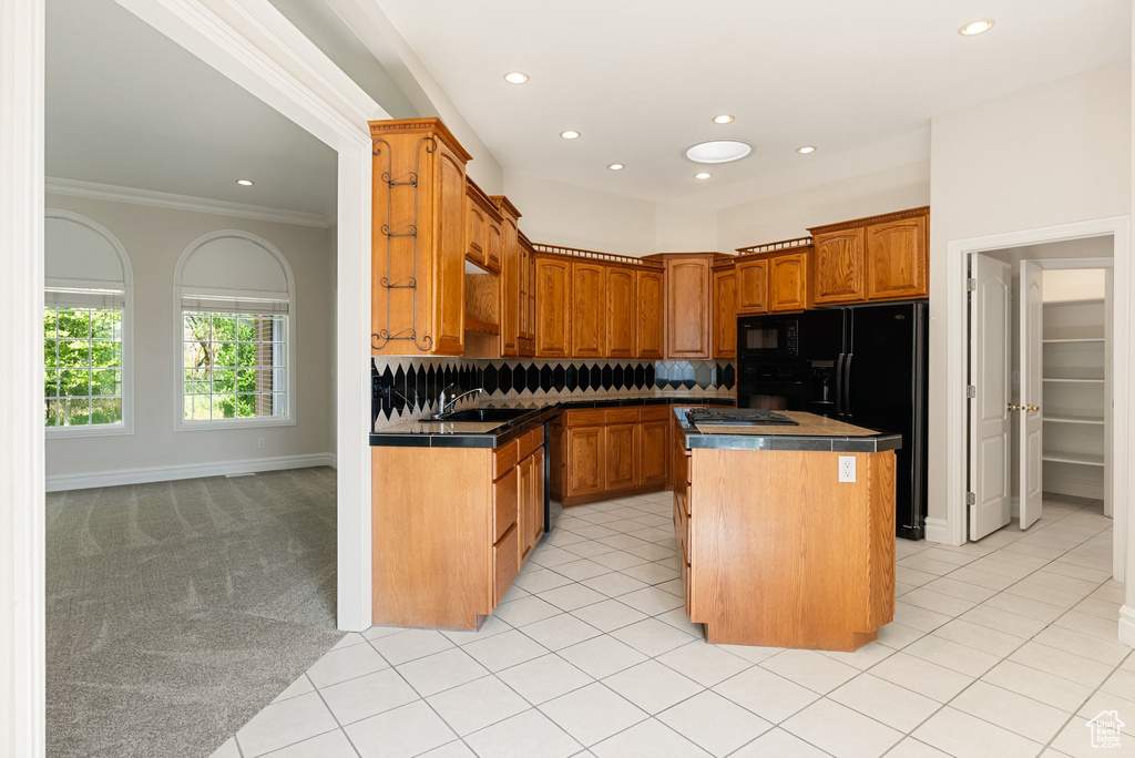 Kitchen with black appliances, recessed lighting, a kitchen island, tasteful backsplash, and crown molding