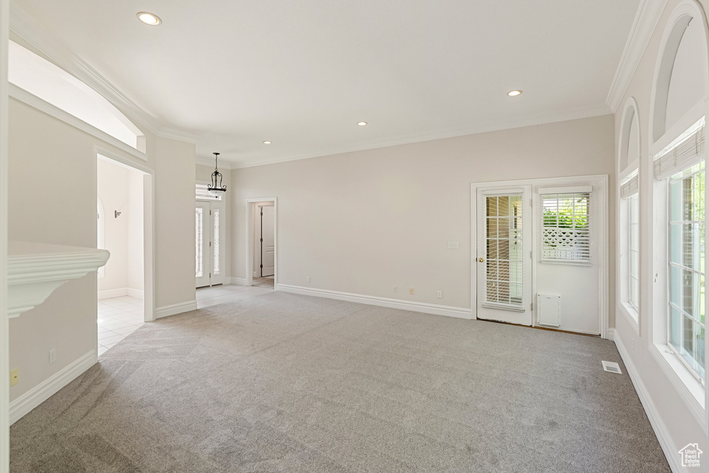 Spare room featuring light colored carpet, ornamental molding, and recessed lighting