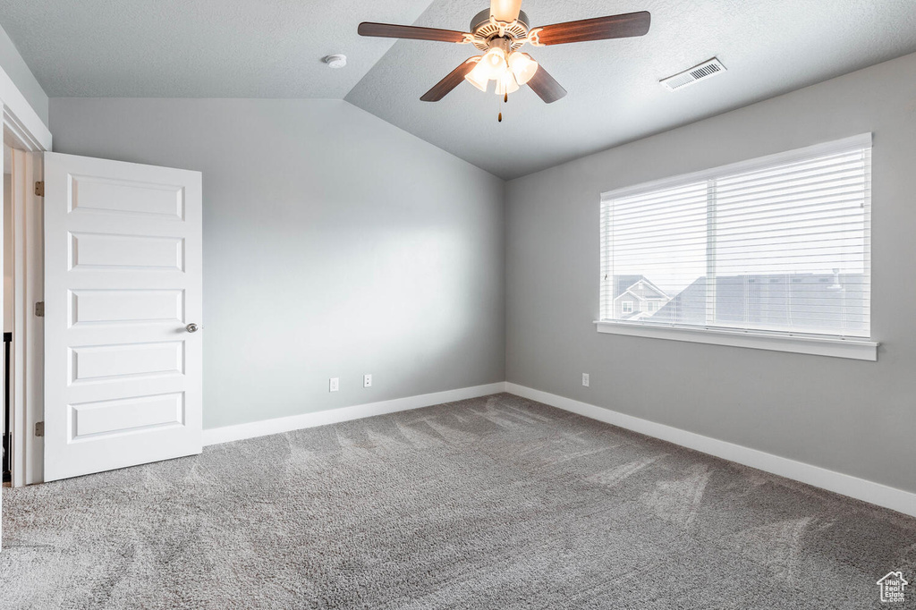 Unfurnished room with carpet, vaulted ceiling, and a ceiling fan