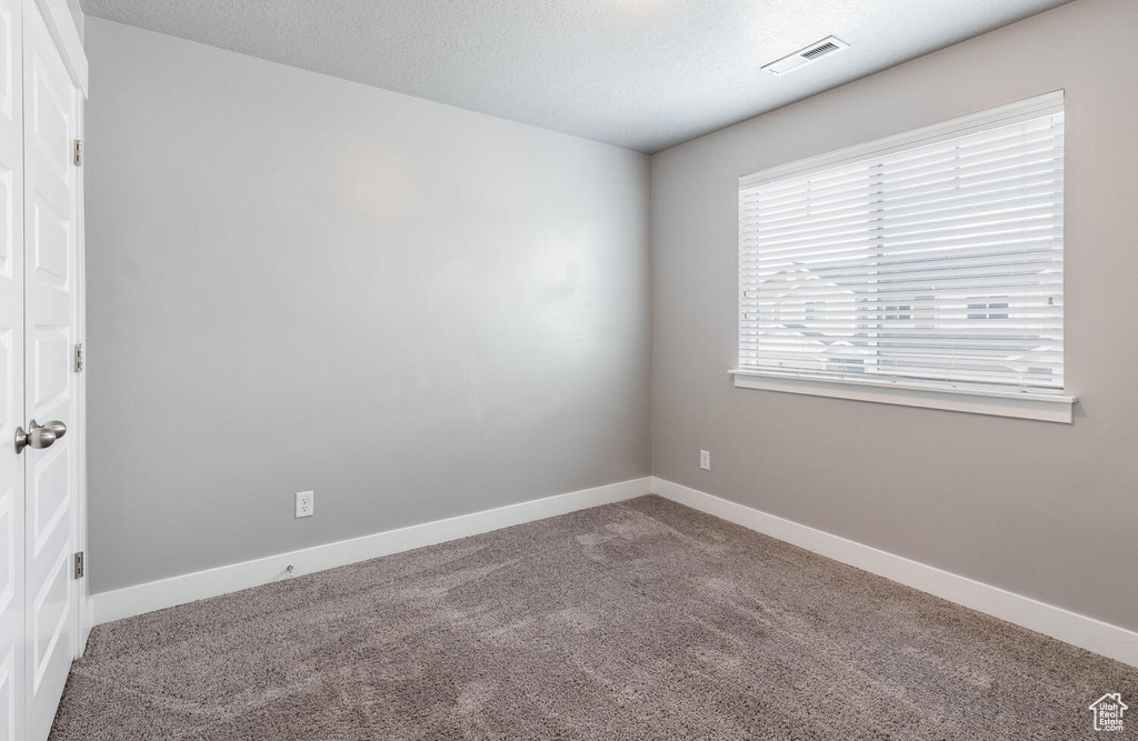 Carpeted empty room featuring baseboards