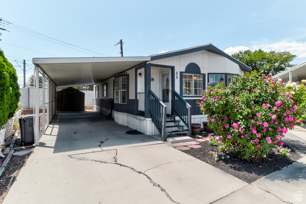 Manufactured / mobile home with concrete driveway and a carport