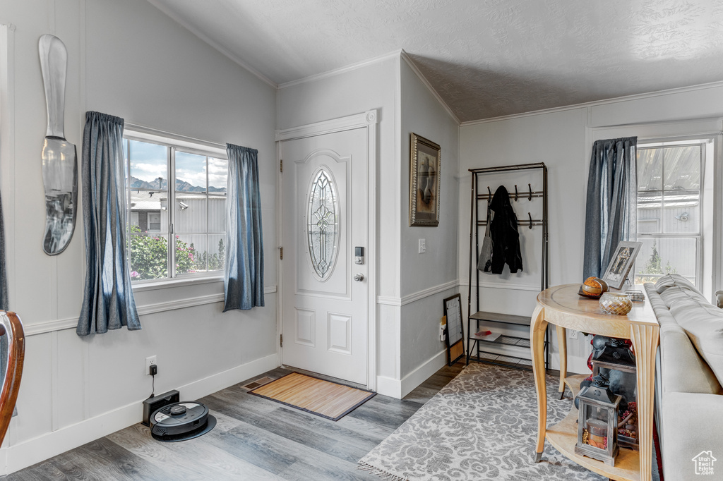 Entryway featuring wood finished floors and crown molding