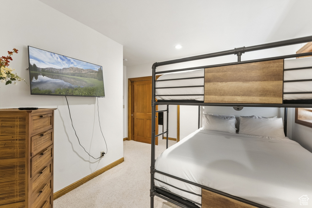 Unfurnished bedroom featuring light carpet and baseboards