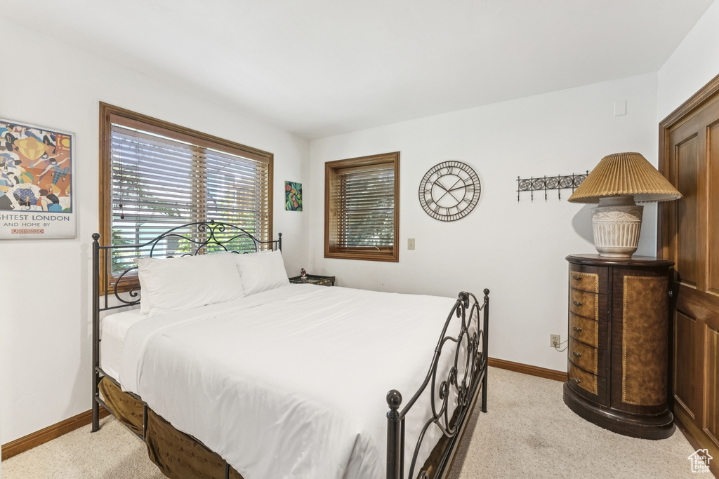 Bedroom featuring light carpet