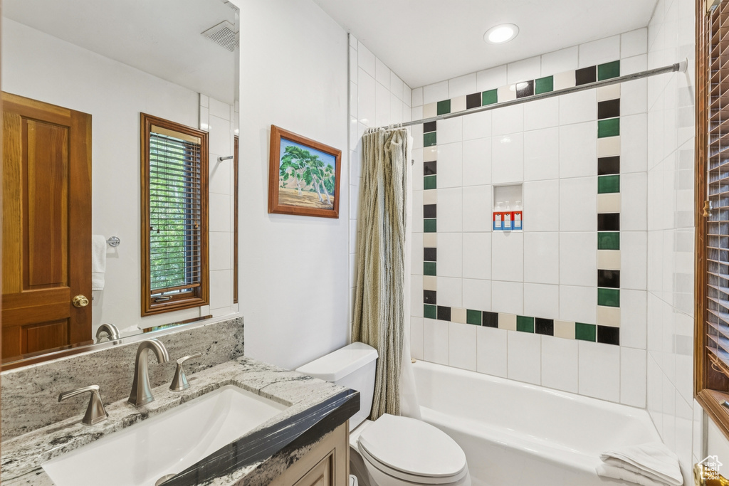 Bathroom featuring vanity and shower / bath combination with curtain